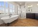 This bathroom has wood floors, a claw foot tub, and a glass shower with a dark wood vanity at 10057 S Shadow Hill Dr, Lone Tree, CO 80124