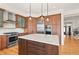 Modern kitchen with stainless steel appliances, center island, hardwood floors, and custom cabinetry at 10057 S Shadow Hill Dr, Lone Tree, CO 80124