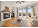 Inviting living room with a fireplace, large windows, and an area rug over the hardwood floors at 10057 S Shadow Hill Dr, Lone Tree, CO 80124