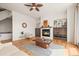 Cozy living room with a fireplace, ceiling fan, and a decorative area rug on the wood floor at 10057 S Shadow Hill Dr, Lone Tree, CO 80124