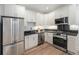 Modern kitchen featuring stainless steel appliances, sleek black countertops, and bright white cabinetry at 719 W 7Th Ave, Denver, CO 80204