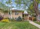 Charming brick home featuring mature trees, manicured lawn, and lush landscaping at 746 Birch St, Denver, CO 80220