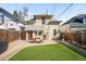 Backyard featuring a patio with seating, artificial grass, and a privacy fence at 4718 W 34Th Ave, Denver, CO 80212