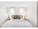 Bright bedroom features two windows, modern lamps, a bed with white comforter, and stylish pillows at 4718 W 34Th Ave, Denver, CO 80212