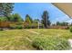 Expansive backyard with lush green lawn, mature trees, a wooden fence, and potential for outdoor enjoyment at 2902 S Meade St, Denver, CO 80236