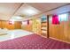 A finished basement living area with ample space, wood paneling, unique carpet, and natural lighting at 2902 S Meade St, Denver, CO 80236