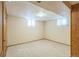 A finished basement with paneled walls, carpeted floors, and natural lighting offering versatile living space at 2902 S Meade St, Denver, CO 80236