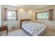 A cozy bedroom with two windows, a double bed, and neutral carpet at 2902 S Meade St, Denver, CO 80236