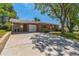 Charming brick home with a well-manicured front yard, driveway, garage, and a covered carport at 2902 S Meade St, Denver, CO 80236