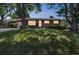 Charming brick home with well-manicured lawn and mature trees on a sunny day at 2902 S Meade St, Denver, CO 80236