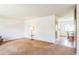 Bright living room with neutral carpet and ample natural light, leading to dining area at 2902 S Meade St, Denver, CO 80236
