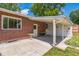 A covered patio area features an attached brick home with concrete flooring, perfect for outdoor entertaining at 2902 S Meade St, Denver, CO 80236