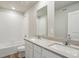 Bathroom with double vanity sinks, white cabinets, white tile and a shower-tub combo at 48195 Shetland Dr, Bennett, CO 80102