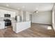 Open-concept kitchen featuring stainless appliances, light countertops and wood floors, seamlessly flowing into the living area at 48195 Shetland Dr, Bennett, CO 80102