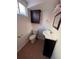 Small bathroom featuring a toilet, vanity with sink, mirror, and a dark wooden cabinet above the toilet at 1245 Yates St, Denver, CO 80204