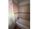 Bathroom featuring a tub with tiled walls, a door, and updated fixtures at 1245 Yates St, Denver, CO 80204