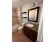 Bathroom featuring a vanity with granite countertops, shelves, tub, and tiled walls at 1245 Yates St, Denver, CO 80204