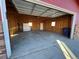 Interior view of an empty garage featuring a white cabinet, windows, and a concrete floor at 1245 Yates St, Denver, CO 80204