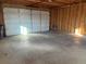 Spacious garage interior featuring a concrete floor and wood-framed walls, and a closed garage door at 1245 Yates St, Denver, CO 80204