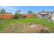 Backyard with wooden fence and green lawn, offering a serene outdoor space with mature trees at 5491 Lowell Blvd, Denver, CO 80221