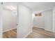Wide hallway featuring updated flooring, access to multiple rooms, and natural light from windows at 5491 Lowell Blvd, Denver, CO 80221