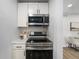 Modern kitchen featuring stainless steel appliances, neutral cabinets, and herringbone backsplash at 5491 Lowell Blvd, Denver, CO 80221