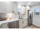 Modern kitchen with stainless steel appliances, neutral cabinets, and updated backsplash at 5491 Lowell Blvd, Denver, CO 80221