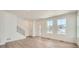 Bright, open-concept living area with hardwood floors and staircase at 708 N Bently St, Watkins, CO 80137