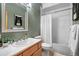 Traditional bathroom with a single sink vanity, a tub with shower, and fresh green walls at 6899 Osprey Ln, Evergreen, CO 80439