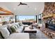 Bright living room with a stone fireplace, comfortable seating, and sliding doors to outdoor deck at 6899 Osprey Ln, Evergreen, CO 80439