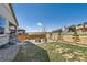 Spacious backyard with a combination of gravel and grass and a wooden fence at 1159 Sunrise Dr, Erie, CO 80516