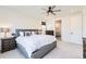 Beautiful bedroom featuring a tufted headboard, modern ceiling fan, and ensuite bathroom at 1159 Sunrise Dr, Erie, CO 80516