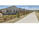 Well-maintained front yard featuring a wooden fence, sidewalk, and drought-resistant landscaping at 1159 Sunrise Dr, Erie, CO 80516