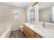 Bathroom featuring double sink vanity, tub, and large mirror at 4857 Tarcoola Ln, Highlands Ranch, CO 80130
