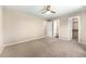 Spacious bedroom with neutral carpet, ceiling fan, and access to closet and bath at 4857 Tarcoola Ln, Highlands Ranch, CO 80130