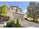 This two-story home has a two-car garage, brick accents, and mature trees at 4857 Tarcoola Ln, Highlands Ranch, CO 80130