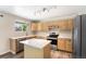 Bright kitchen features stainless steel appliances, an island, light wood cabinets, and wood-look flooring at 4857 Tarcoola Ln, Highlands Ranch, CO 80130