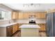 Bright kitchen features stainless steel appliances, an island, light wood cabinets, and wood-look flooring at 4857 Tarcoola Ln, Highlands Ranch, CO 80130