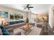 Staged living room open to dining and kitchen, featuring backyard view, ceiling fan, and stylish furnishings at 4857 Tarcoola Ln, Highlands Ranch, CO 80130