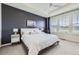 Stylish bedroom showcasing a navy accent wall, tray ceiling, and abundant natural light from large windows at 515 176Th Ave, Broomfield, CO 80023