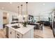 Open-concept kitchen with island, stainless steel sink, and view into dining and living area at 515 176Th Ave, Broomfield, CO 80023