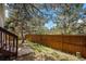 Backyard with a wood fence, a small patio, and mature trees for privacy at 16724 E Hialeah Ave, Centennial, CO 80015