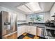 Updated kitchen features stainless steel appliances, white cabinetry, and a garden view at 16724 E Hialeah Ave, Centennial, CO 80015