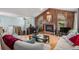 Cozy living room featuring a fireplace, wood paneling, and hardwood floors at 16724 E Hialeah Ave, Centennial, CO 80015