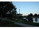 Scenic view of a pond at dusk featuring a lamp post and lush greenery at 16724 E Hialeah Ave, Centennial, CO 80015