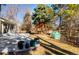 The backyard includes a stone patio, a small tree house, plants, a greenhouse and a grassy lawn at 6368 S Emporia Cir, Englewood, CO 80111