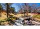 A walking trail alongside a creek in a backyard with large trees and green space at 6368 S Emporia Cir, Englewood, CO 80111