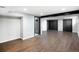 Finished basement with wood floors, dark doors and hardware, and black beam at 6368 S Emporia Cir, Englewood, CO 80111
