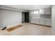 Clean basement area with neutral tile floors, storage cabinets, and space for various uses at 6368 S Emporia Cir, Englewood, CO 80111