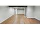 Open basement area with wood floors, black beams and open doorways offers flexible living space at 6368 S Emporia Cir, Englewood, CO 80111